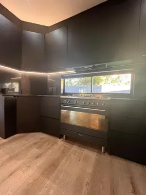 a kitchen with black cabinets and a stove top oven at 2 on Aurora Island in Durbanville