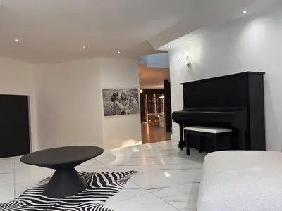 a living room with a black piano and a stool at 2 on Aurora Island in Durbanville