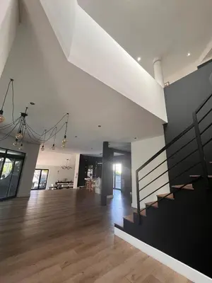a living room with a staircase and a dining room at 2 on Aurora Island in Durbanville