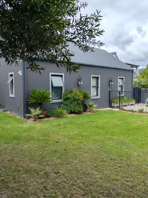 a gray house with a yard in front of it at Franschhoek Guest Suite in Franschhoek