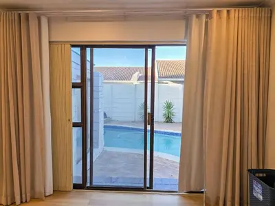 a room with a window with a view of a pool at 12 Sleeper Luxury Villa Chaffinch in Cape Town