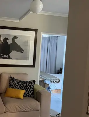 a living room with a couch and a bedroom at De Eike in Stellenbosch