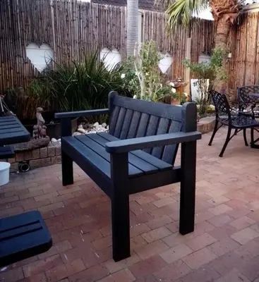 a blue bench sitting on a brick patio at Le Bay Lodge in Gordonʼs Bay