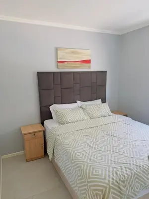 a bedroom with a bed and a painting on the wall at Blouberg Beach Gem 5 Min Walk in Cape Town