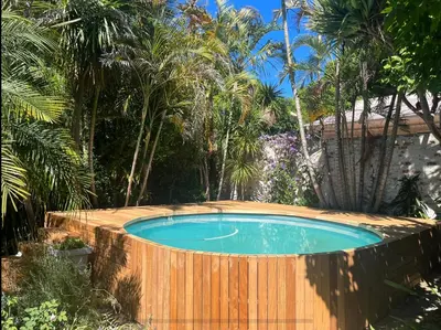 a swimming pool with a wooden fence around it at Catlovers Corner in Paarl