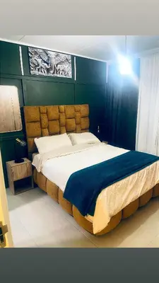a bedroom with a large bed with a blue headboard at Explore Convenience And Style In A Prime Location in Richwood