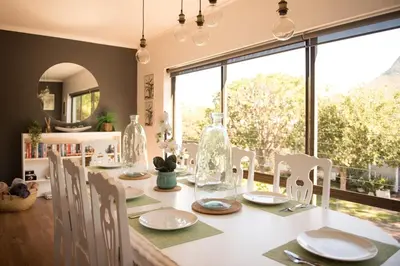 a dining room with a table and chairs and a window at CalTye On Sea in Hermanus