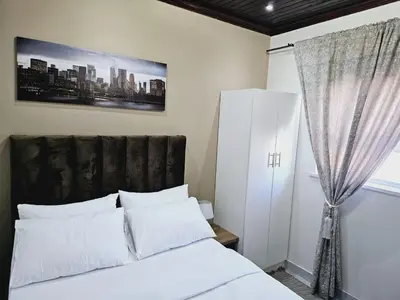a bedroom with a white bed and a window at Evernice Guest House in Cape Town