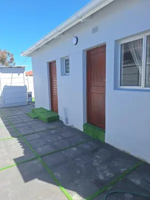 a white house with a door and a driveway at Evernice Guest House in Cape Town