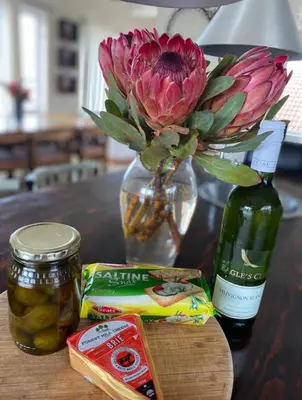 a vase with a flower and a jar of pickles on a table at Fynbos Mountain View in Kleinmond