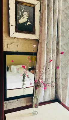 a mirror and two vases with flowers on a table at Fynbos Mountain View in Kleinmond
