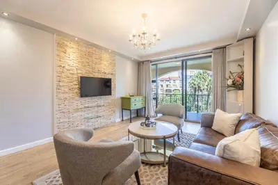 a living room with a couch and a table at Portifino on lake 221 The Island Club in Cape Town