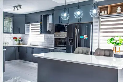 a kitchen with blue cabinets and a white counter top at Sukoluhle Guest House in Cape Town