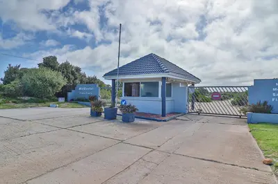 a small blue building in a parking lot at Die Steenbras in Fisherhaven