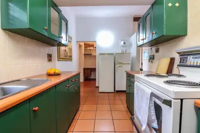 a kitchen with green cabinets and a stove top oven at Die Steenbras in Fisherhaven