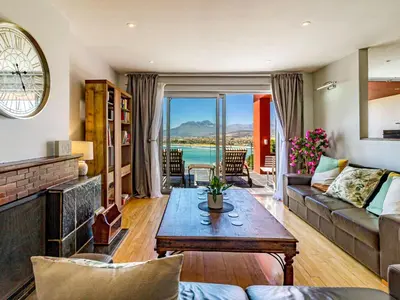 a living room with a couch and a table at 5 Suikerbossie in Gordonʼs Bay