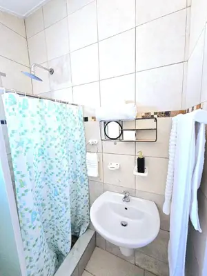 a bathroom with a sink and a shower at Evernice Guest House in Cape Town