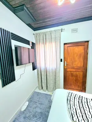 a bedroom with a bed and a wooden door at Evernice Guest House in Cape Town