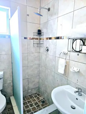 a bathroom with a shower and a sink at Evernice Guest House in Cape Town