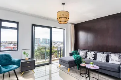 a living room with a couch and a chair at Knightsbridge 702W by CTHA in Cape Town