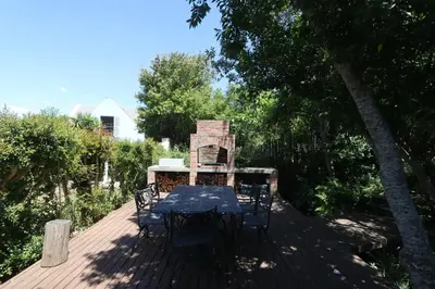 a patio with a table and chairs on a deck at Greyton Hideaway-on-Disa in Greyton