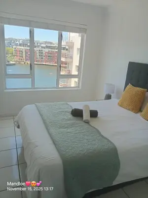 a bed in a room with a large window at Classy Budget Apartment in Tyger Valley