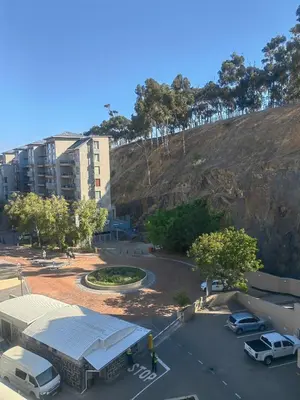 a parking lot with cars parked in front of a building at Classy Budget Apartment in Tyger Valley