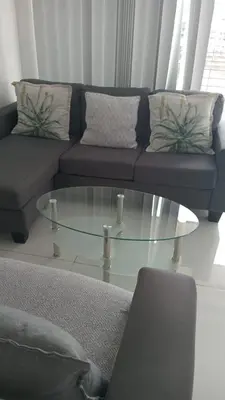 a living room with a couch and a glass coffee table at Classy Budget Apartment in Tyger Valley