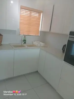 a white kitchen with a sink and a window at Classy Budget Apartment in Tyger Valley