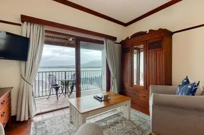 a living room with a view of the ocean at Berg en Zee Guesthouse in Gordonʼs Bay