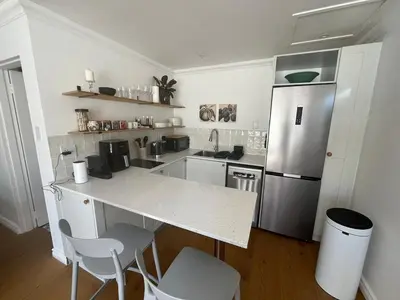 a kitchen with a counter and a refrigerator at The Sultan Cottage in Stellenbosch