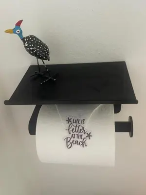 a paper bird sitting on top of a toilet paper roll at Waterberry Hideaway in Pringle Bay