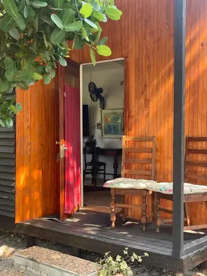 an open door to a house with a bench on the porch at Waterberry Hideaway in Pringle Bay
