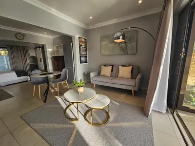 a living room with a couch and a table at Induli on Sage in Plattekloof