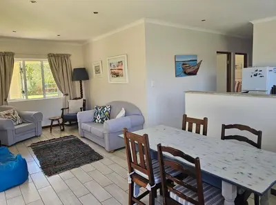 a kitchen and living room with a table and chairs at Torbrae Cottage in Hermanus