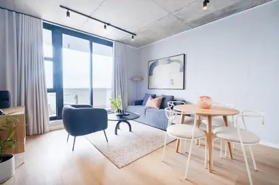 a living room with a table and chairs and a couch at 721 Riverlands - Lux 2 Bedroom Apartment in Cape Town