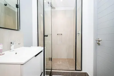a bathroom with a shower with a sink and a toilet at 721 Riverlands - Lux 2 Bedroom Apartment in Cape Town