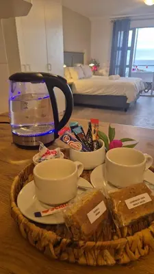 a table with a bowl of food and a fish tank at Seaspray Apartment Blauberg in Cape Town
