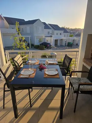 a blue table and chairs on a balcony with a table at Casa Voliere in Stellenbosch