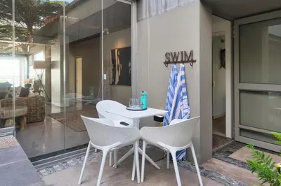 a patio with white chairs and a table with a flag at Exclusive Estate, Panoramic Beauty, Watersports in Lake Marina