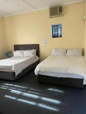 two beds sitting next to each other in a room at Heritage lodge in Cape Town