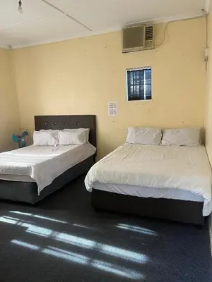 two beds sitting next to each other in a room at Heritage lodge in Cape Town