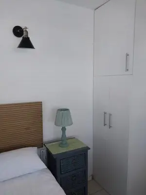 a bedroom with a bed and a lamp on a night stand at Catch And Release Hermanus in Hermanus