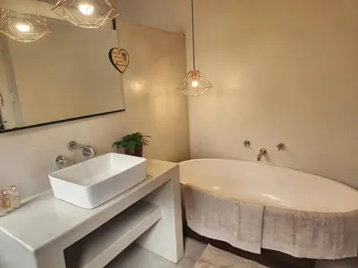 a bathroom with a sink and a tub and a mirror at Home in Somerset Ridge in Somerset West
