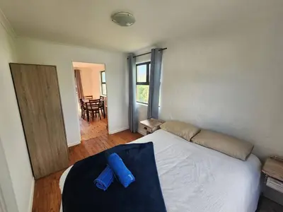 a bedroom with a bed with a blue pillow on it at The Sandpiper - The Alikreukel , Pringle Bay in Pringle Bay