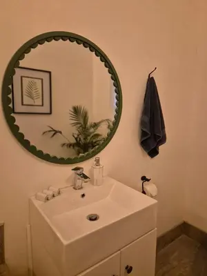 a bathroom with a white sink and a mirror at Under the Maple in Rawsonville
