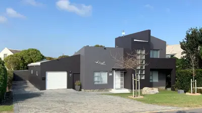 a black house with a driveway at Seagull Apartment Hermanus in Hermanus