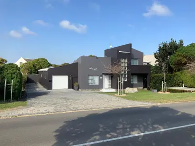 a large black house with a driveway at Seagull Apartment Hermanus in Hermanus