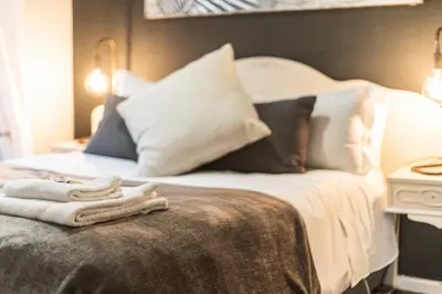 a bed with pillows and towels on top of it at Seagull Apartment Hermanus in Hermanus