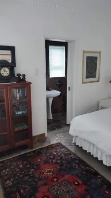 a bedroom with a bed and a bathroom with a sink at Zoute Zoene in Kleinmond